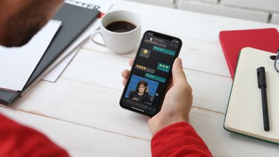 Ένα άτομο που κρατά ένα iPhone που εμφανίζει μια συνομιλία μέσω WhatsApp. 