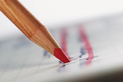 Ένα κόκκινο μολύβι εντυπωσιακό από τη γραφή σε χαρτί.