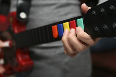 Πρόσωπο που κρατά τον ελεγκτή Guitar Hero