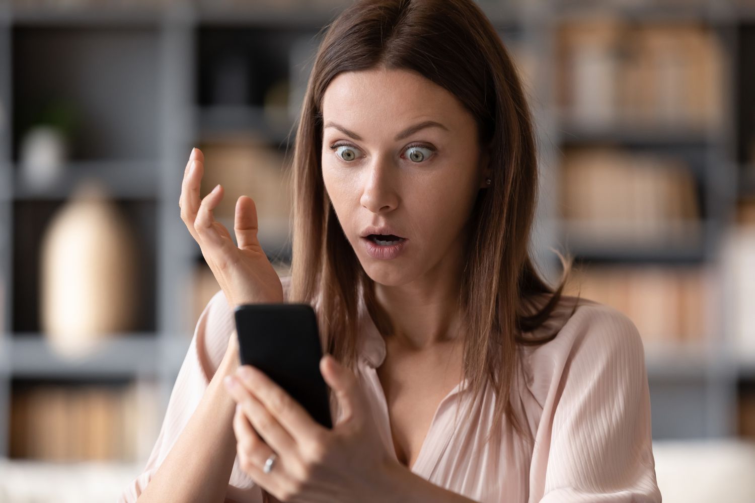 Κοντινό πλάνο σοκαρισμένης γυναίκας που κοιτάζει την οθόνη του κινητού τηλεφώνου